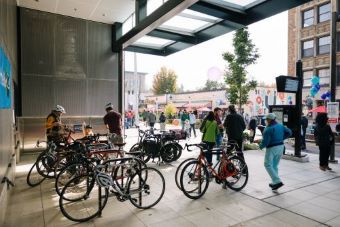Link light rail車站的自行車停車架附近有許多自行車和行人。